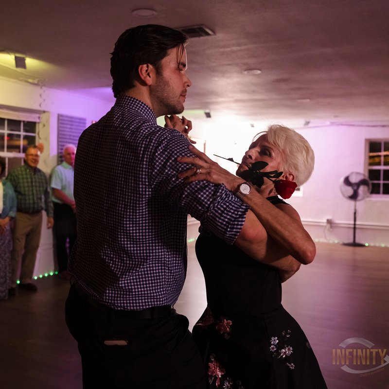 A man and woman joyfully tango dancing at a wedding reception in Gainesville, FL.
