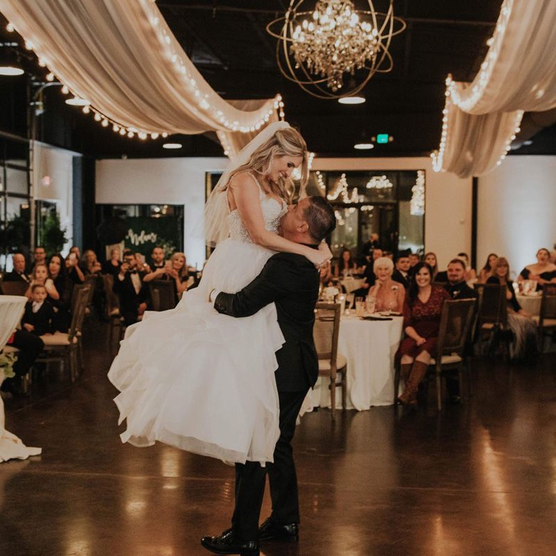 A couple dances at their wedding in Gainesville, FL, with friends and family celebrating around them.