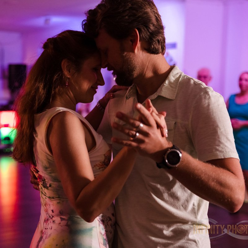 Vibrant lights set the scene as a couple dances, showcasing the Latin dance style in Gainesville, FL