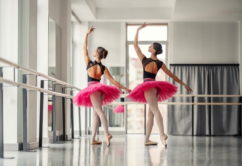 Two dancers gracefully poised in an elegant studio performing ballet dance in Gainesville, FL